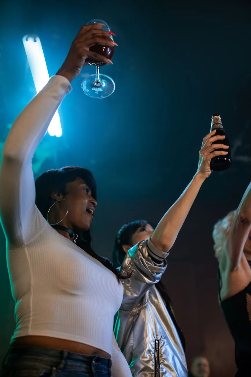 Lively night out with friends raising glasses in a vibrant club setting.