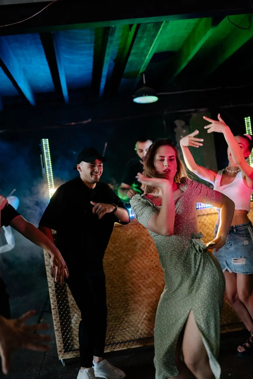 Exciting nightclub scene with people dancing and enjoying music. Vibrant energy and colorful lights.